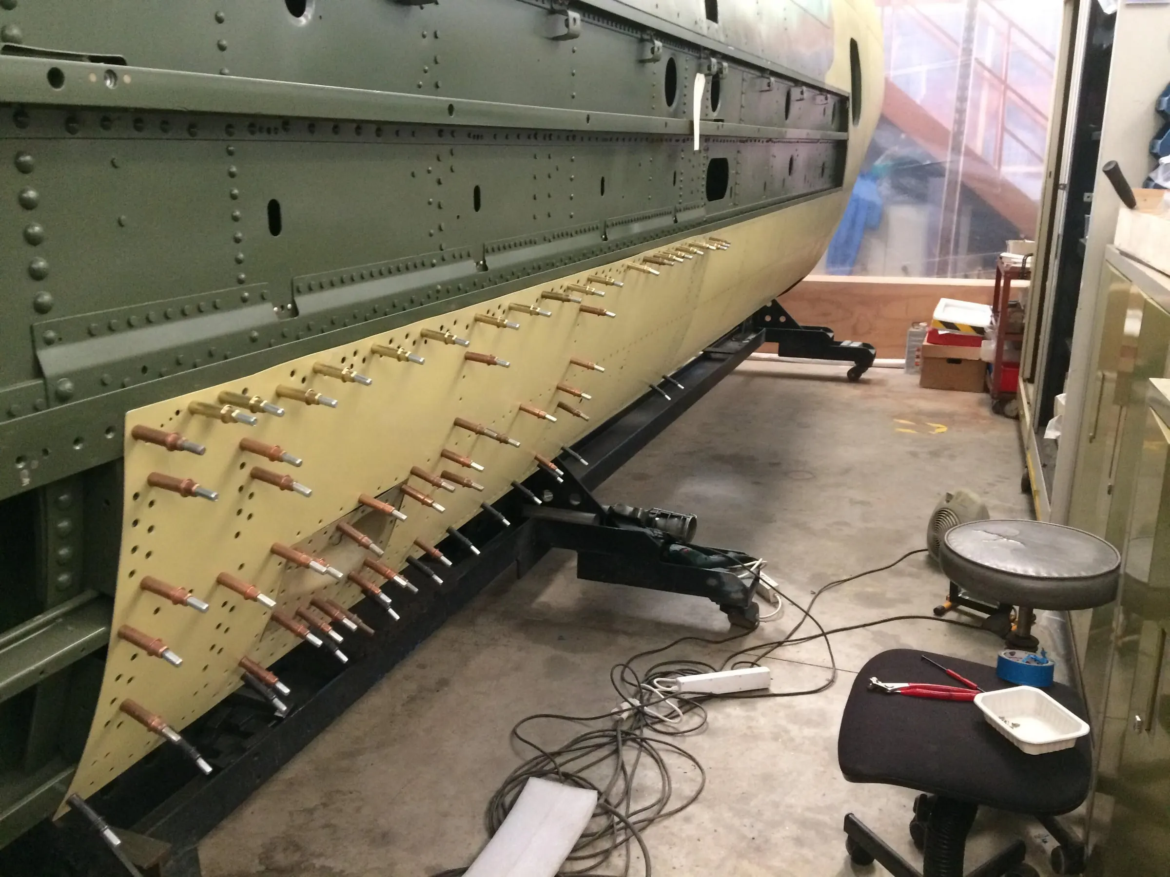 Restauration de l'A-26 Invader : rivetage des tôles sur le flanc gauche du fuselage