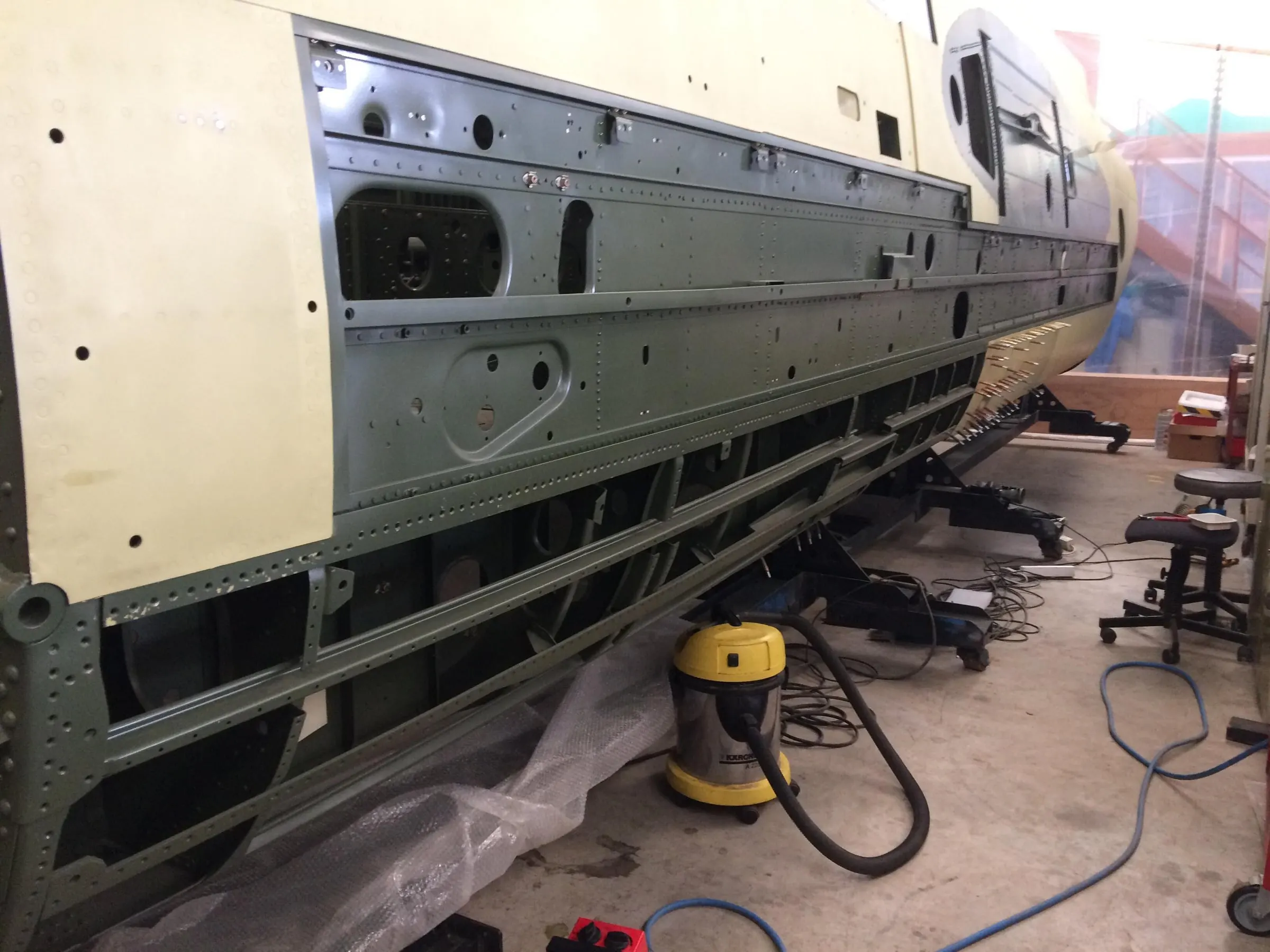 Restauration de l'A-26 Invader : rivetage des tôles sur le flanc gauche du fuselage
